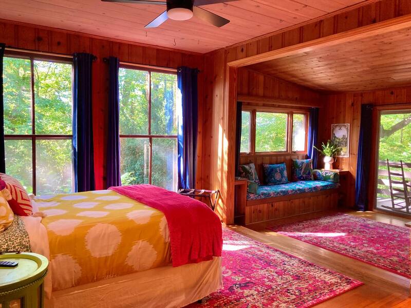 Main floor bedroom with spacious seating area and forest view.